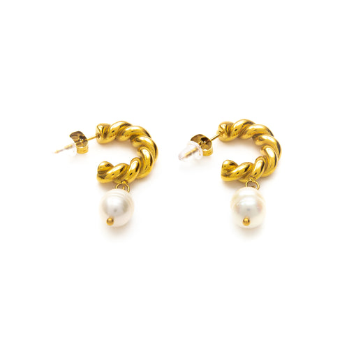 Gold hoop earrings with pearl drops on a white background